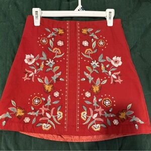 Red mini skirt with embroidered flowers.